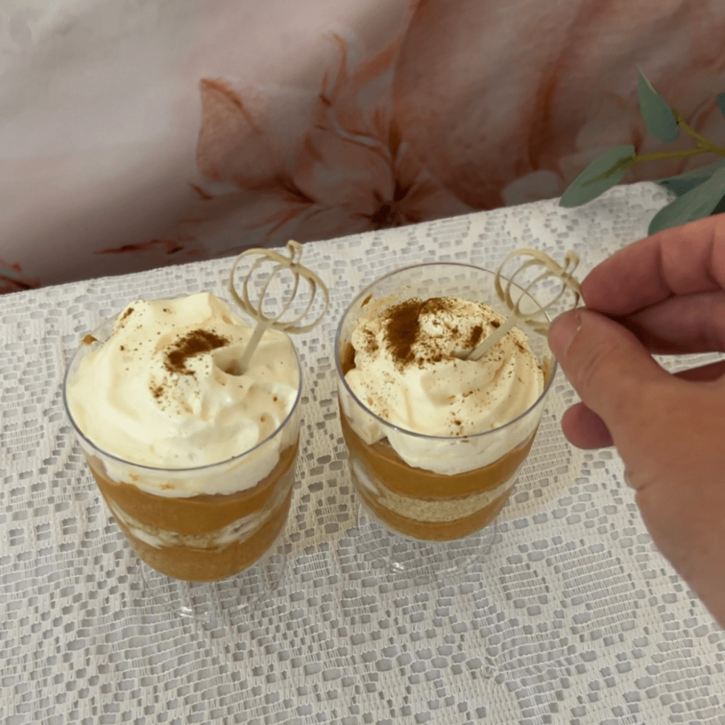 close up of putting a pumpkin drink topper into a whipped pumpkin parfait