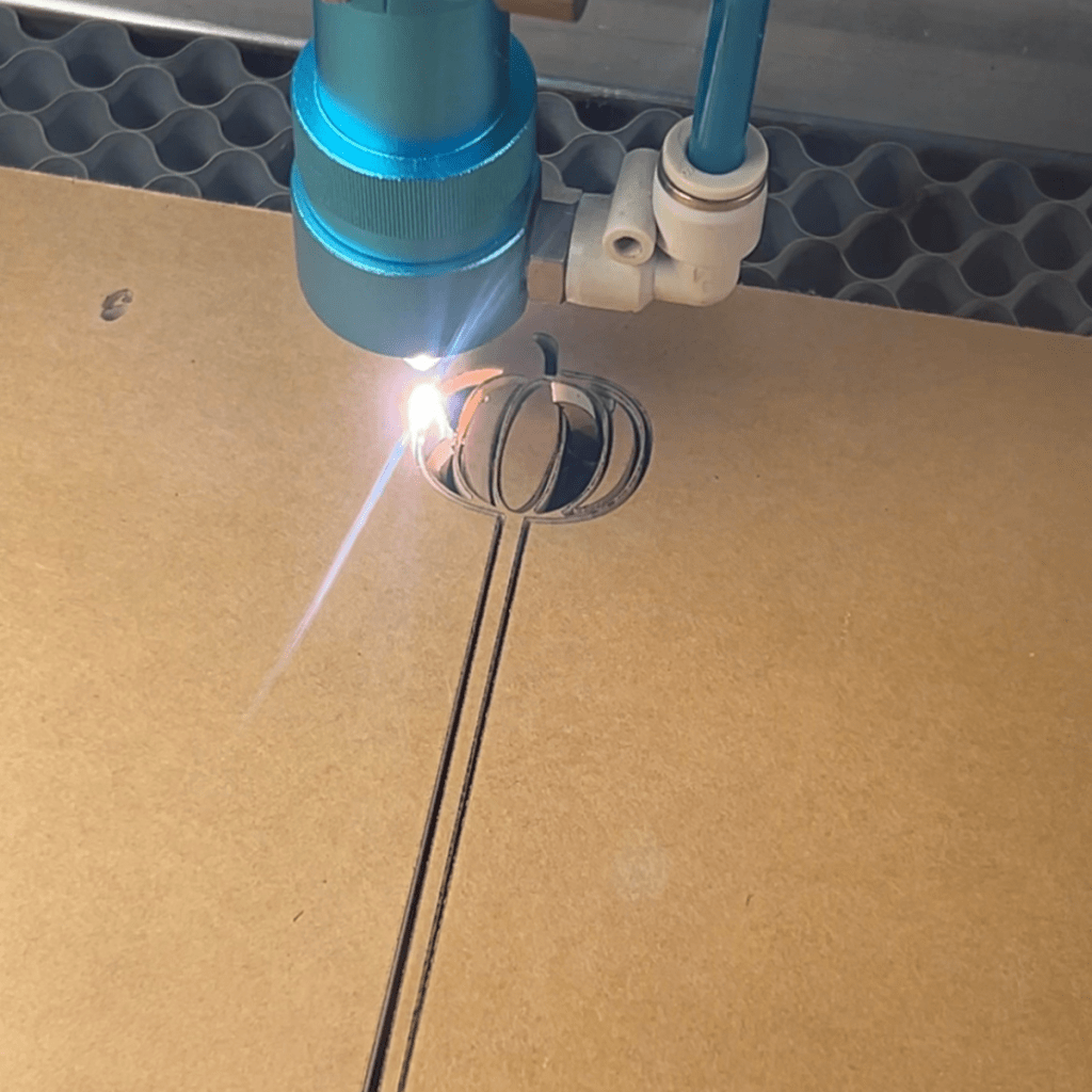 close up of a thunder laser cutting a pumpkin out of acrylic