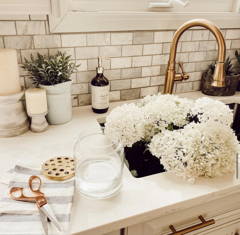 flowers in sink white gold faucet modern kitchen with tile backsplash 